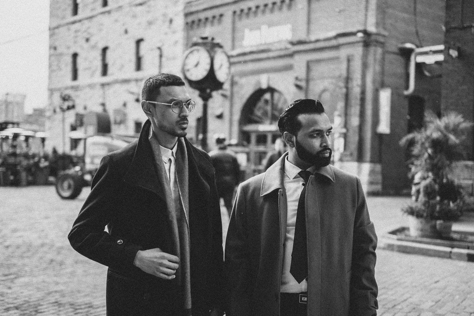 Two suited protection professionals standing on a city street